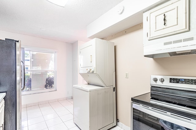 kitchen with white cabinetry, stainless steel fridge, light tile floors, stacked washer and clothes dryer, and electric range oven