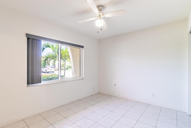 unfurnished room with a textured ceiling, light tile flooring, and ceiling fan