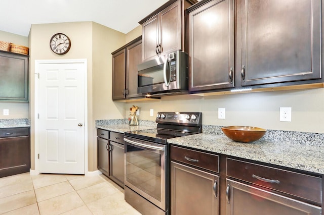 kitchen with light tile floors, light stone counters, electric range, and dark brown cabinetry