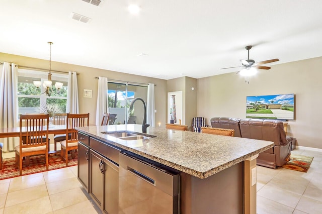 kitchen featuring ceiling fan with notable chandelier, light tile flooring, sink, a center island with sink, and stainless steel dishwasher