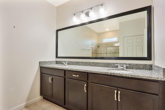 bathroom with a shower, double sink, large vanity, and tile flooring