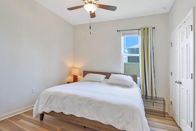 bedroom with a closet, light hardwood / wood-style floors, and ceiling fan