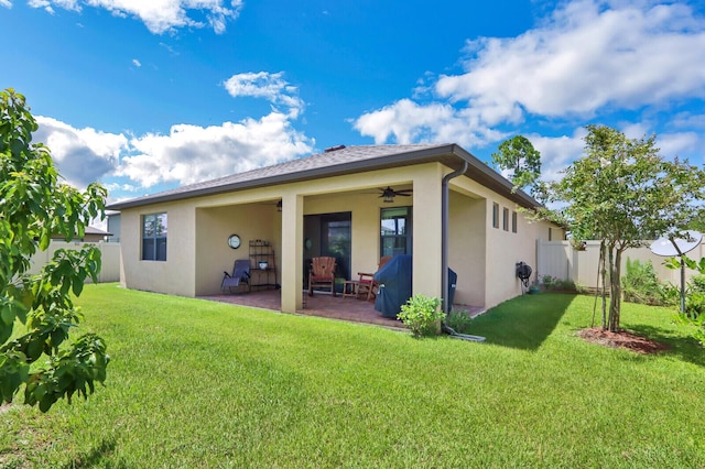 back of property featuring a lawn, ceiling fan, and a patio