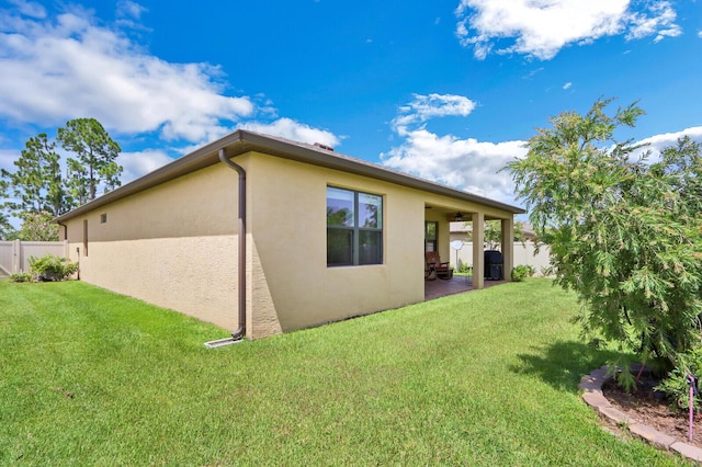 back of property featuring a lawn and a patio area