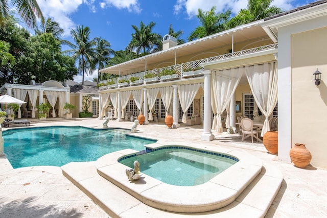 view of pool featuring a patio and an in ground hot tub