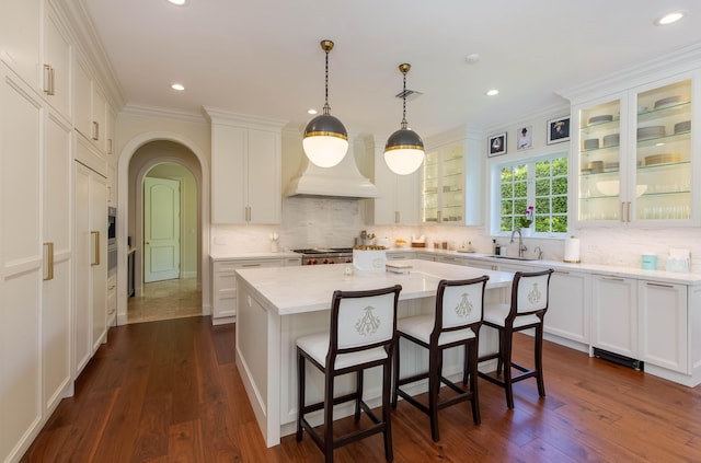 kitchen featuring backsplash, dark hardwood / wood-style floors, white cabinets, and a center island