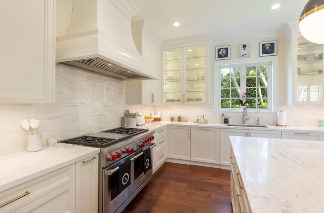 kitchen with premium range hood, double oven range, tasteful backsplash, sink, and light stone counters