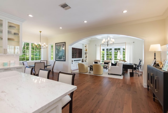 dining room featuring crown molding, dark hardwood / wood-style floors, and an inviting chandelier