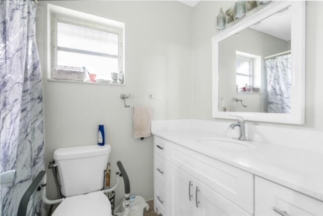 bathroom featuring a wealth of natural light, toilet, and large vanity