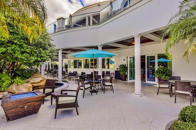 view of patio / terrace featuring a fire pit and a balcony