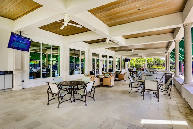 sunroom / solarium featuring ceiling fan, beam ceiling, coffered ceiling, and ornate columns