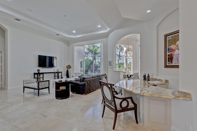 office space with light tile floors, a notable chandelier, and a tray ceiling