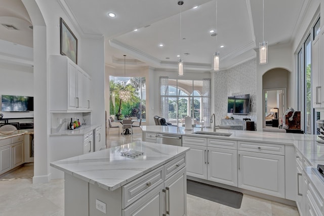 kitchen featuring sink, stainless steel dishwasher, white cabinets, and hanging light fixtures