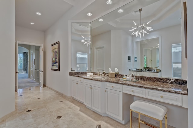 bathroom with tile flooring, a wealth of natural light, vanity, and a chandelier