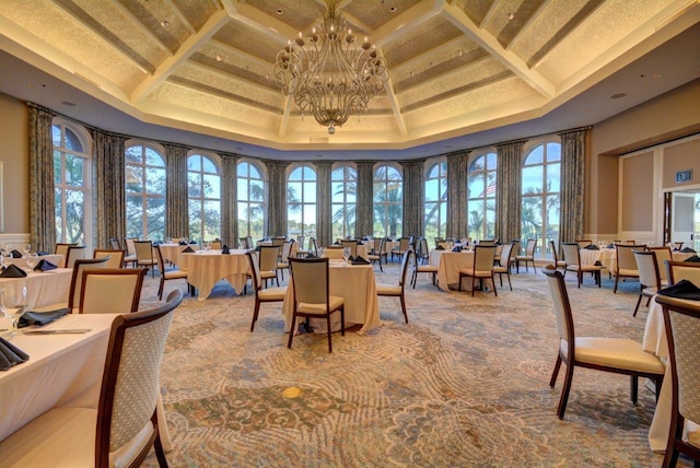 carpeted dining area featuring a notable chandelier, coffered ceiling, a wealth of natural light, and a raised ceiling