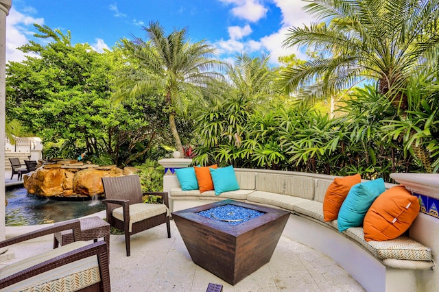 view of terrace with an outdoor living space with a fire pit