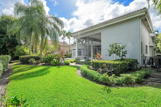 back of property with a lawn and a lanai