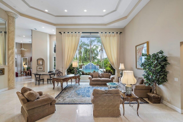 living room with a tray ceiling, ceiling fan, light tile floors, and a wealth of natural light