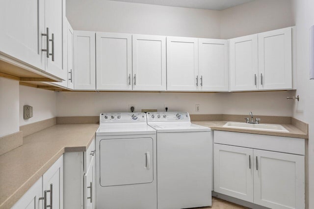 washroom with cabinets, separate washer and dryer, and sink