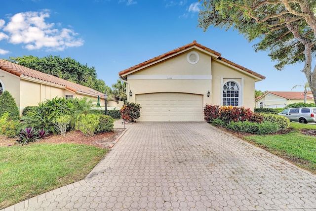 mediterranean / spanish-style home featuring a front lawn and a garage