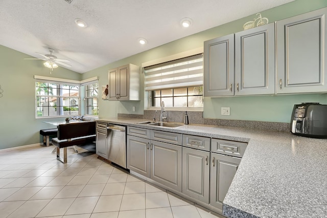 kitchen featuring plenty of natural light, stainless steel dishwasher, ceiling fan, and sink