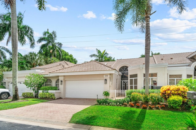 mediterranean / spanish-style home featuring a front yard and a garage