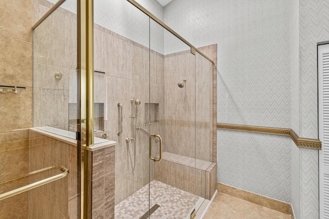 bathroom with tile flooring, a shower with shower door, and tile walls