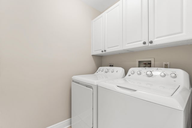 washroom with washer hookup, cabinets, and washer and clothes dryer