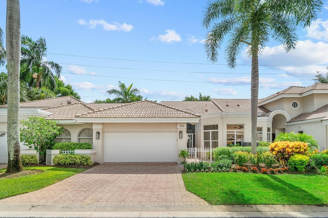 mediterranean / spanish-style house with a front yard and a garage