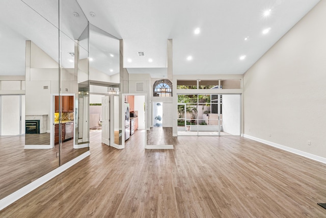 interior space featuring hardwood / wood-style floors and high vaulted ceiling