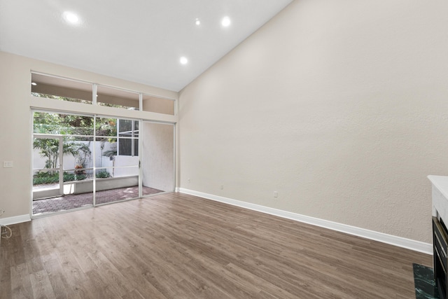 unfurnished room with dark hardwood / wood-style floors and lofted ceiling