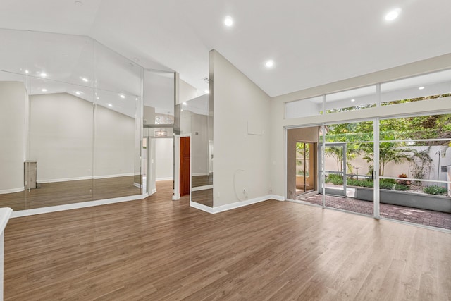 unfurnished room with dark wood-type flooring and high vaulted ceiling