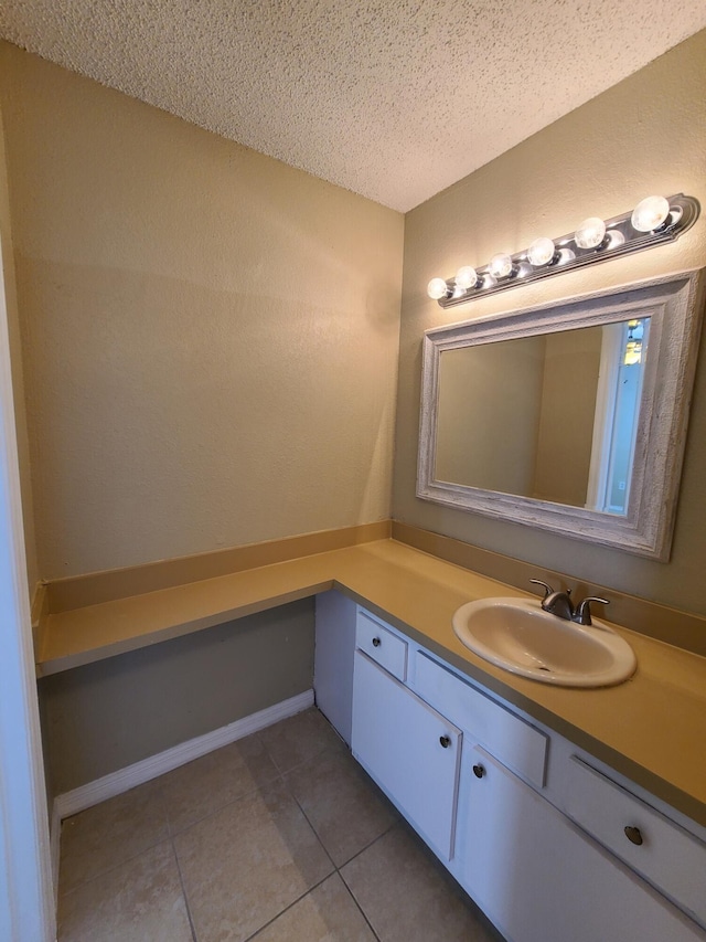 bathroom with a textured ceiling, tile floors, and vanity with extensive cabinet space