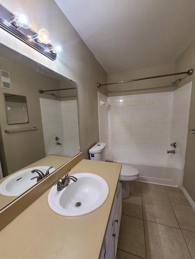 full bathroom with toilet, vanity with extensive cabinet space, tiled shower / bath, tile flooring, and a textured ceiling