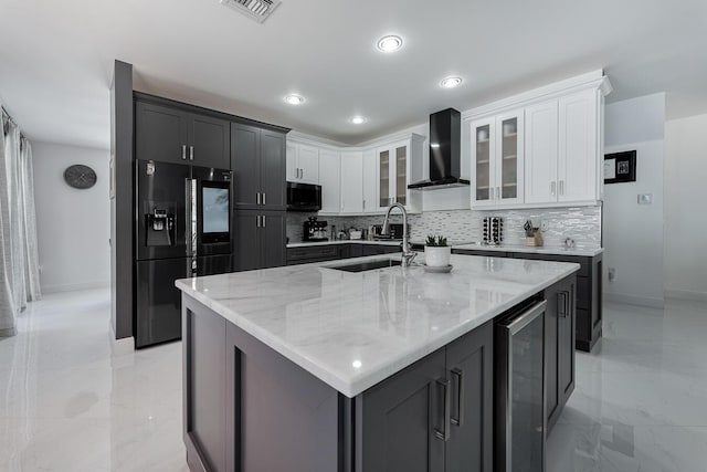 kitchen featuring a kitchen island with sink, black fridge with ice dispenser, white cabinets, wine cooler, and wall chimney exhaust hood