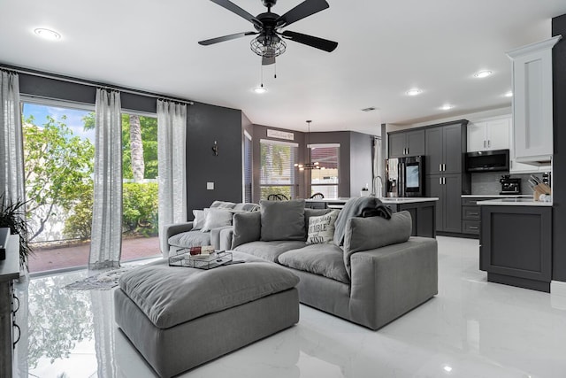 tiled living room with ceiling fan and sink