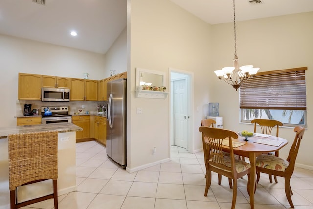 tiled dining space featuring high vaulted ceiling and a chandelier