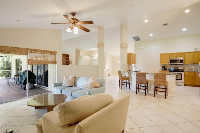 living room featuring light tile floors, ceiling fan, high vaulted ceiling, and sink