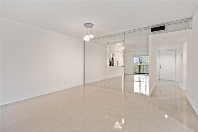 tiled spare room with a textured ceiling