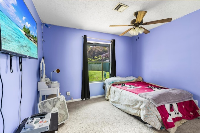 carpeted bedroom with a textured ceiling and ceiling fan