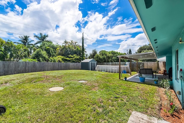 view of yard featuring outdoor lounge area, a patio area, and a storage unit