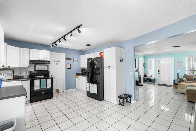 kitchen with black appliances, light tile flooring, white cabinets, a textured ceiling, and rail lighting