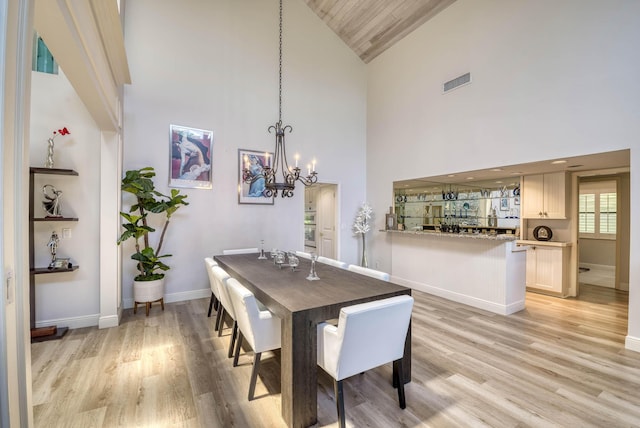 dining room featuring a chandelier, light hardwood / wood-style floors, high vaulted ceiling, and wooden ceiling