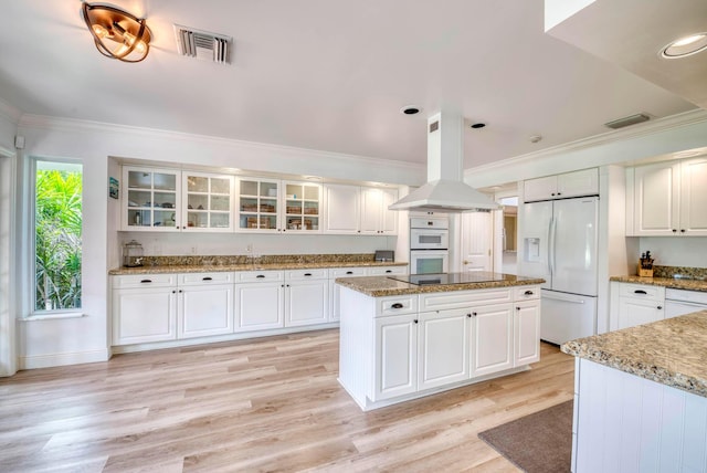 kitchen featuring white cabinets, white appliances, and island exhaust hood