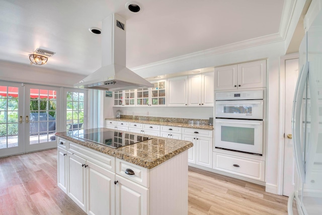 kitchen with a center island, french doors, white appliances, island range hood, and white cabinets