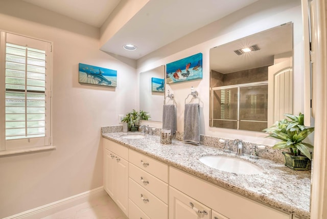 bathroom with tile patterned flooring, vanity, a shower with door, and plenty of natural light