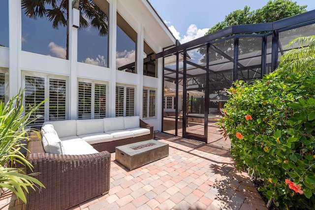 view of patio / terrace with glass enclosure and an outdoor living space with a fire pit