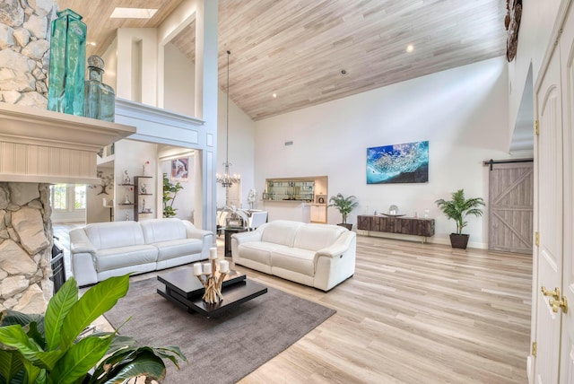 living room featuring light wood-type flooring, a barn door, high vaulted ceiling, and wood ceiling