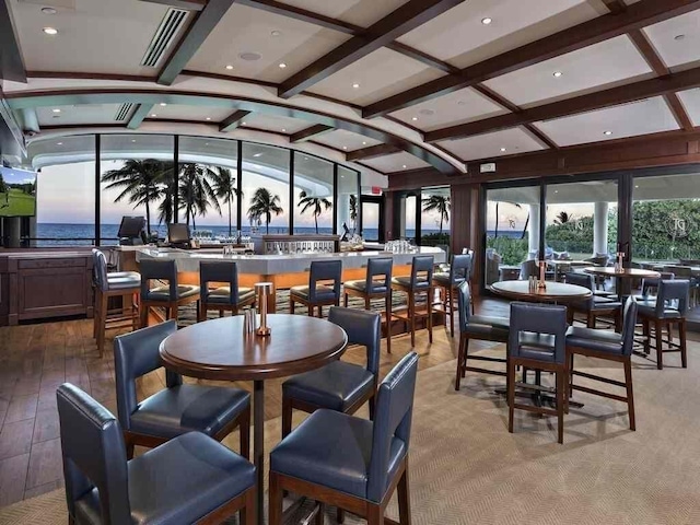 dining area with lofted ceiling with beams and dark wood-type flooring