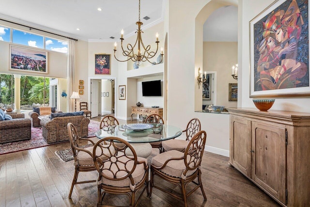 dining room featuring an inviting chandelier, crown molding, dark wood-type flooring, and a high ceiling